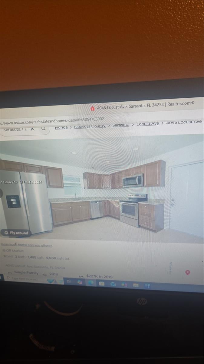 A kitchen features wooden cabinets, stainless steel appliances, and light-colored countertops — 4045 locust # 1, Sarasota FL 34234, SARASOTA, FL