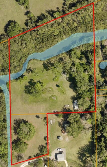 This aerial map shows a property boundary outlined in red over a wooded landscape — 318 PALM AVENUE, OAK HILL, FL