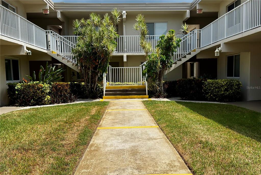 A kitchen features white cabinets, a white stove, a white refrigerator, and wood countertops — 6700 1ST AVENUE S UNIT 103, ST PETERSBURG, FL