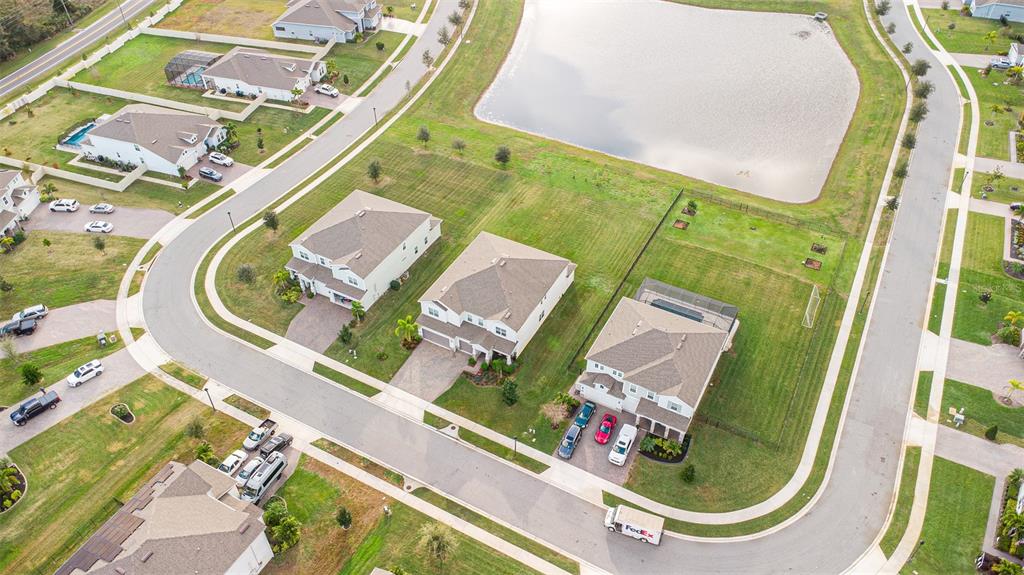 An aerial view shows several suburban houses, a retention pond, and a FedEx truck — 2206 WEATHERLY WAY, ORLANDO, FL