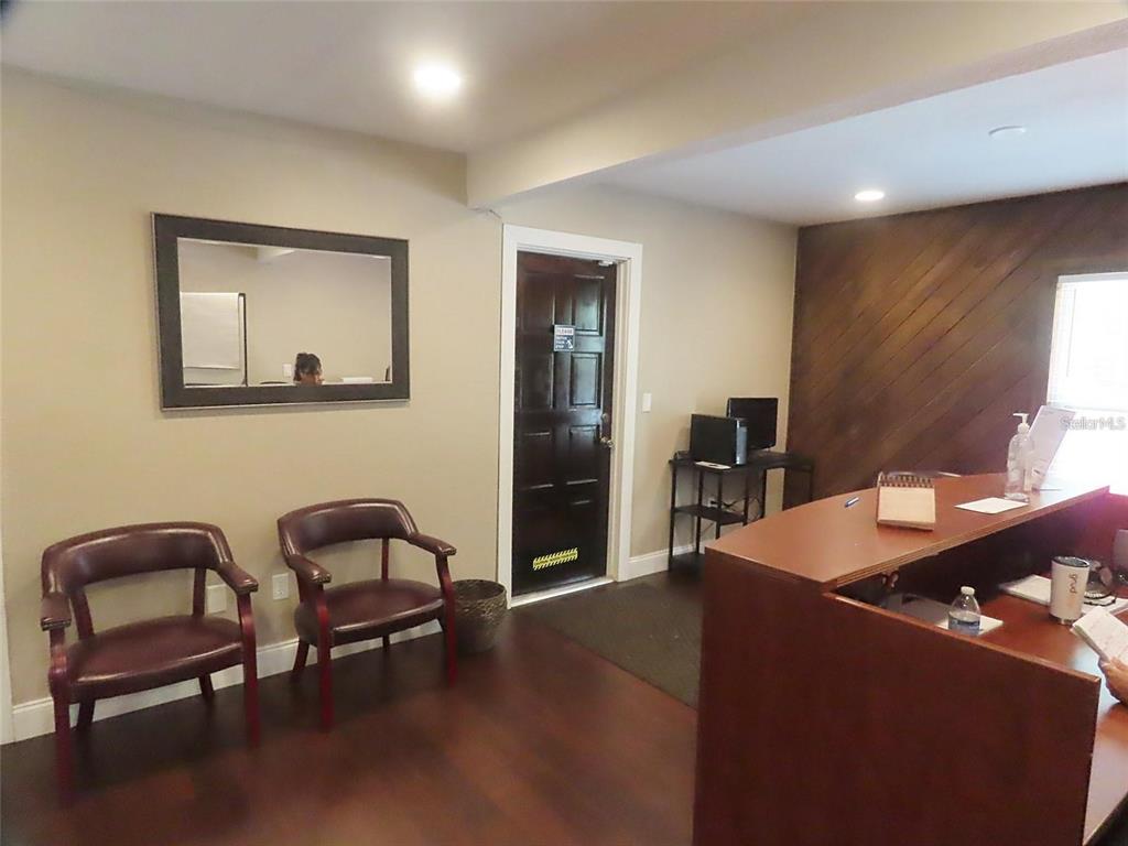 A reception area features two wooden chairs, a desk, and a dark wood-paneled accent wall — 657 MAITLAND AVENUE, ALTAMONTE SPRINGS, FL