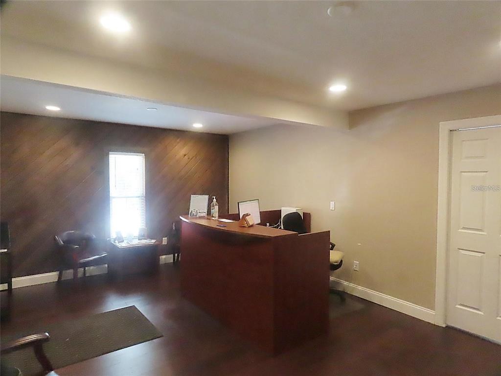 A reception area features a dark wood desk, wood-paneled accent wall, and recessed lighting — 657 MAITLAND AVENUE, ALTAMONTE SPRINGS, FL