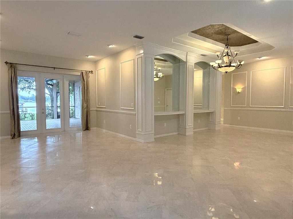 A spacious living room features marble floors, a coffered ceiling, and a built-in wet bar — 3704 SWANS LANDING DRIVE, LAND O LAKES, FL