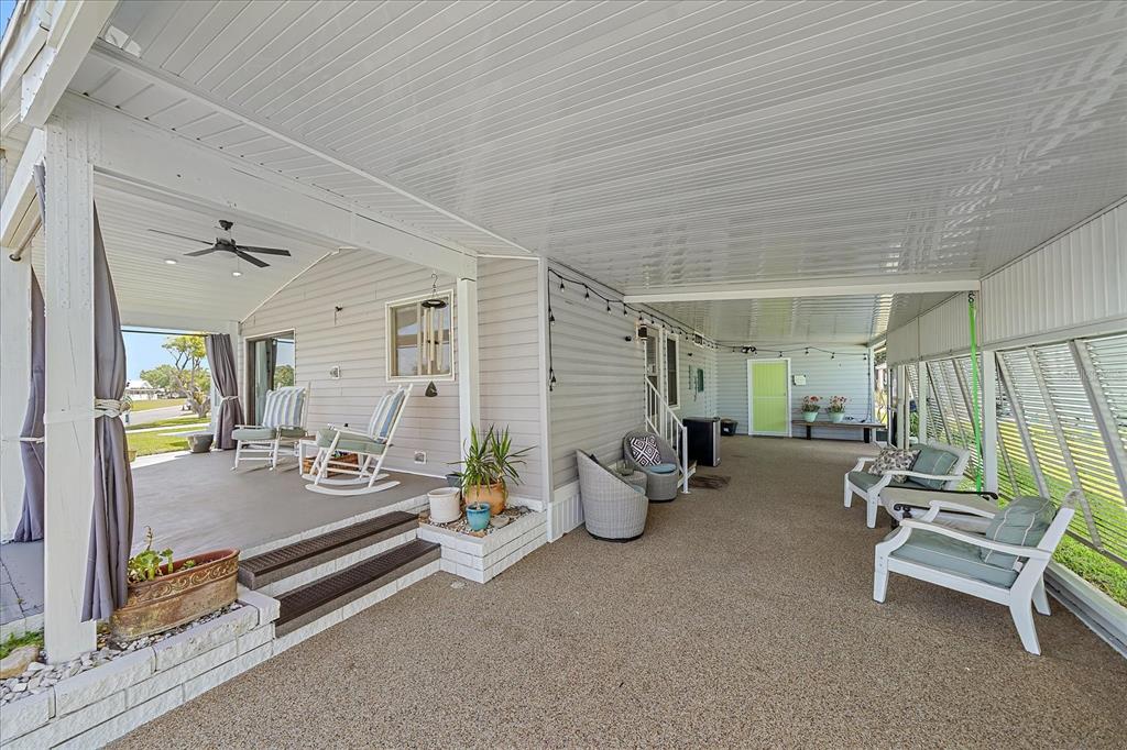 A covered porch with a ceiling fan overlooks a grassy lawn, a road, and a pond — 137 LAKEVIEW DRIVE UNIT 137, PALMETTO, FL