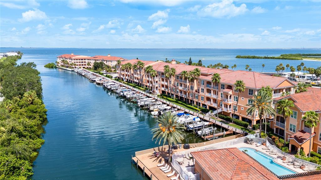 An aerial view shows a multi-story waterfront apartment complex with a boat dock and pool — 5000 CULBREATH KEY WAY UNIT 9316, TAMPA, FL