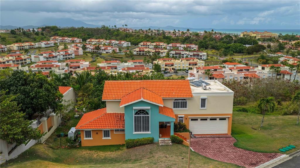 An aerial view of a two-story house with a teal facade and orange tile roof — 5 HARBOUR LIGHTS, HUMACAO, PR