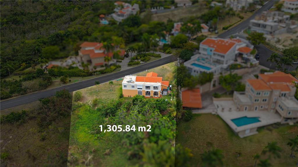 An aerial view shows a two-story house situated on a large, grassy lot — 5 HARBOUR LIGHTS, HUMACAO, PR