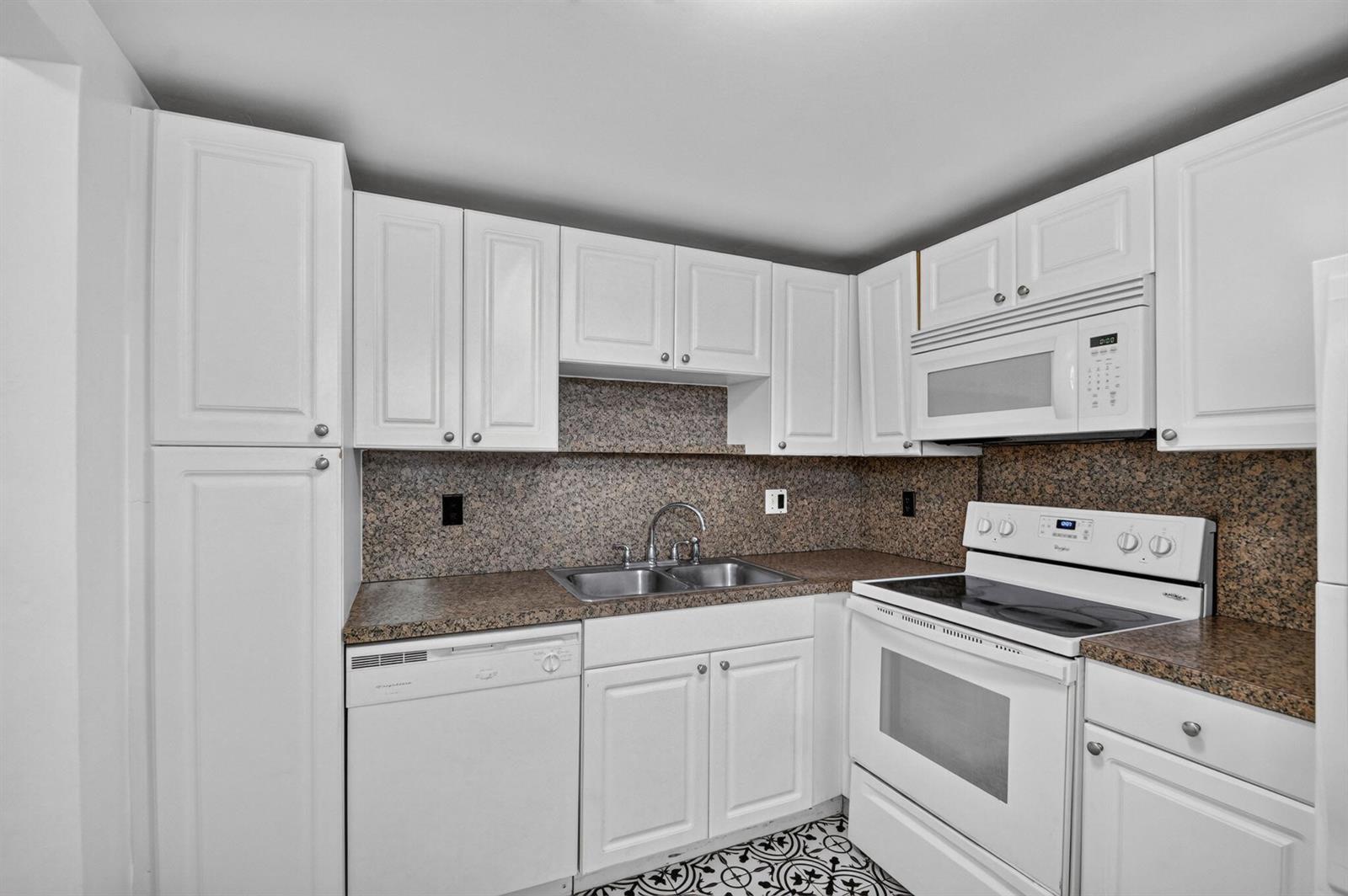 A kitchen with white cabinets, granite countertops, and white appliances — 1505 Crescent Circle # B24, Lake Park FL 33403, LAKE PARK, FL