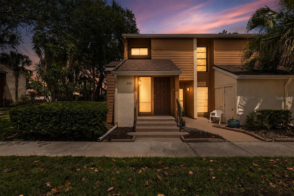 A two-story townhouse exterior features tan siding, a front porch with stairs, and landscaping — 2901 CLUBVIEW DRIVE UNIT U1, ORLANDO, FL