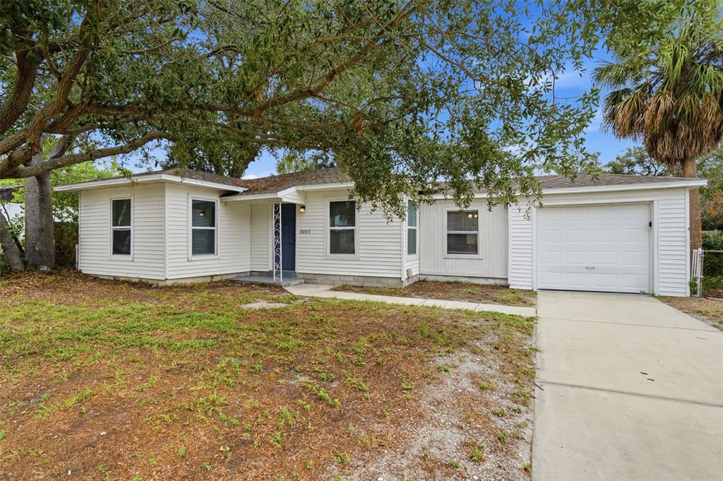 A single-story white house with a garage and a large tree in the front yard — 3003 N ADAMS STREET, TAMPA, FL