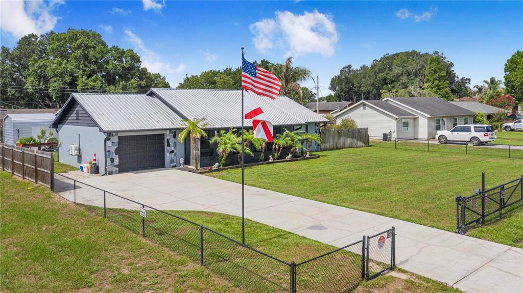 An aerial view shows a single-story house with a metal roof and a fenced yard — 2426 VIEW WAY, LAKELAND, FL