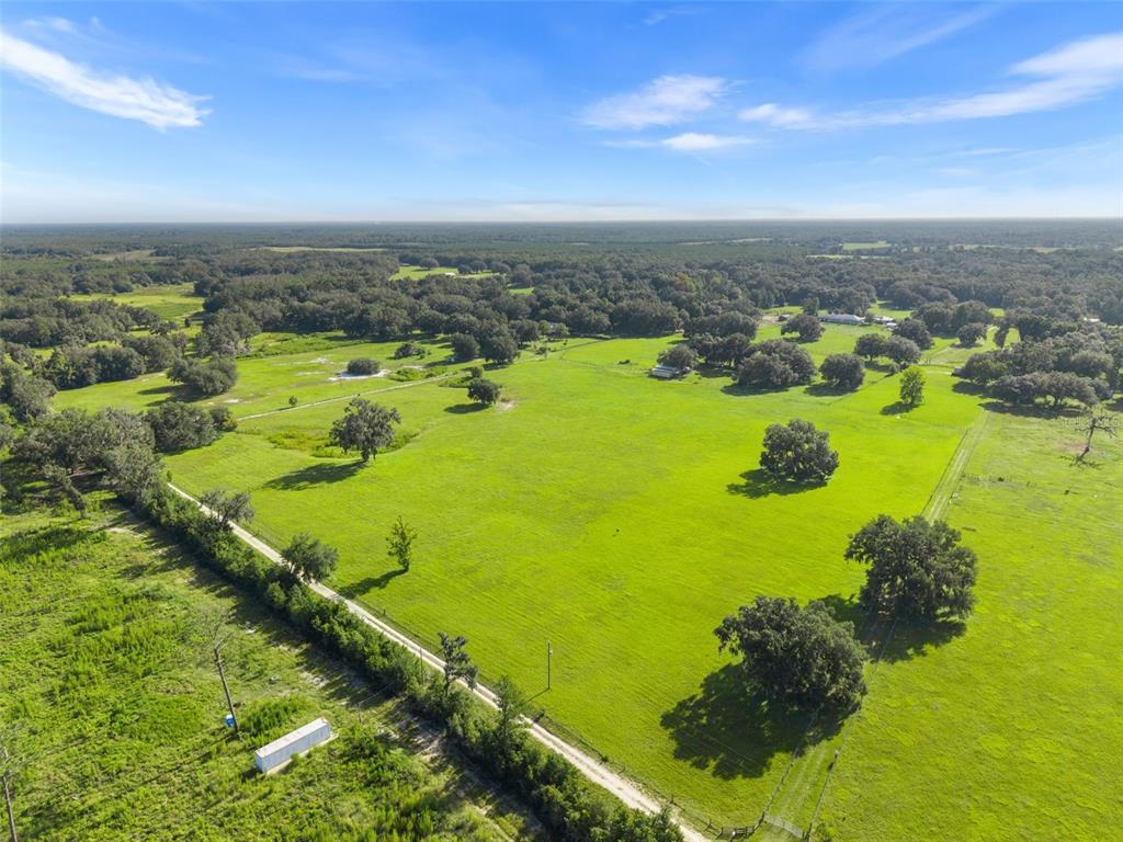 An aerial view shows a large, grassy pasture dotted with oak trees and fenced boundaries — 360 & 390 SE 30TH AVENUE, TRENTON, FL