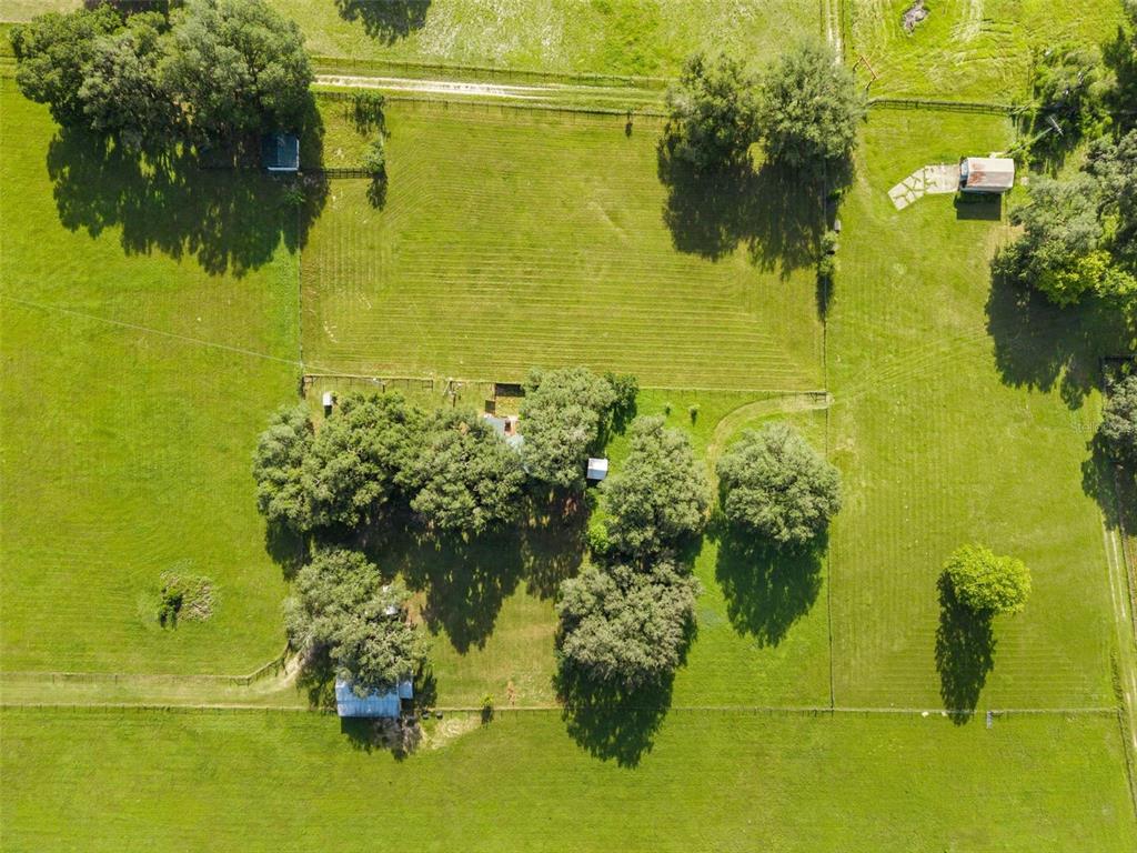 An aerial view shows a rural property with a house, several outbuildings, and fenced pastures — 360 & 390 SE 30TH AVENUE, TRENTON, FL