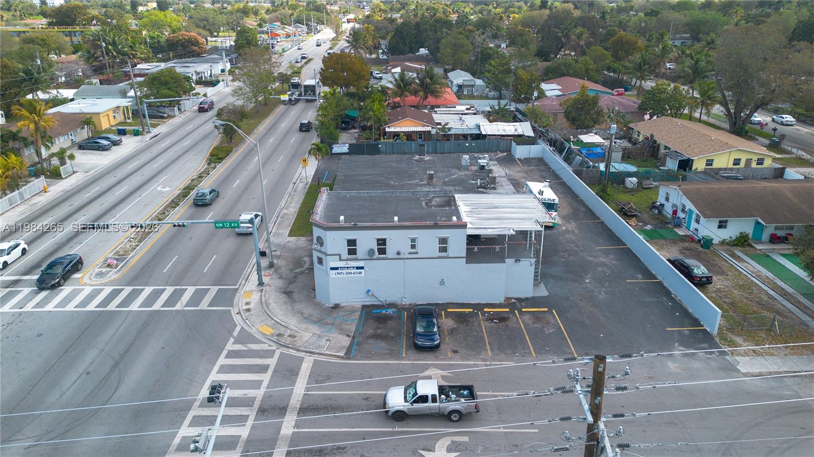 An aerial view shows a commercial building with a parking lot at a street intersection — 1186 NW 103rd St, Miami FL 33150, MIAMI, FL