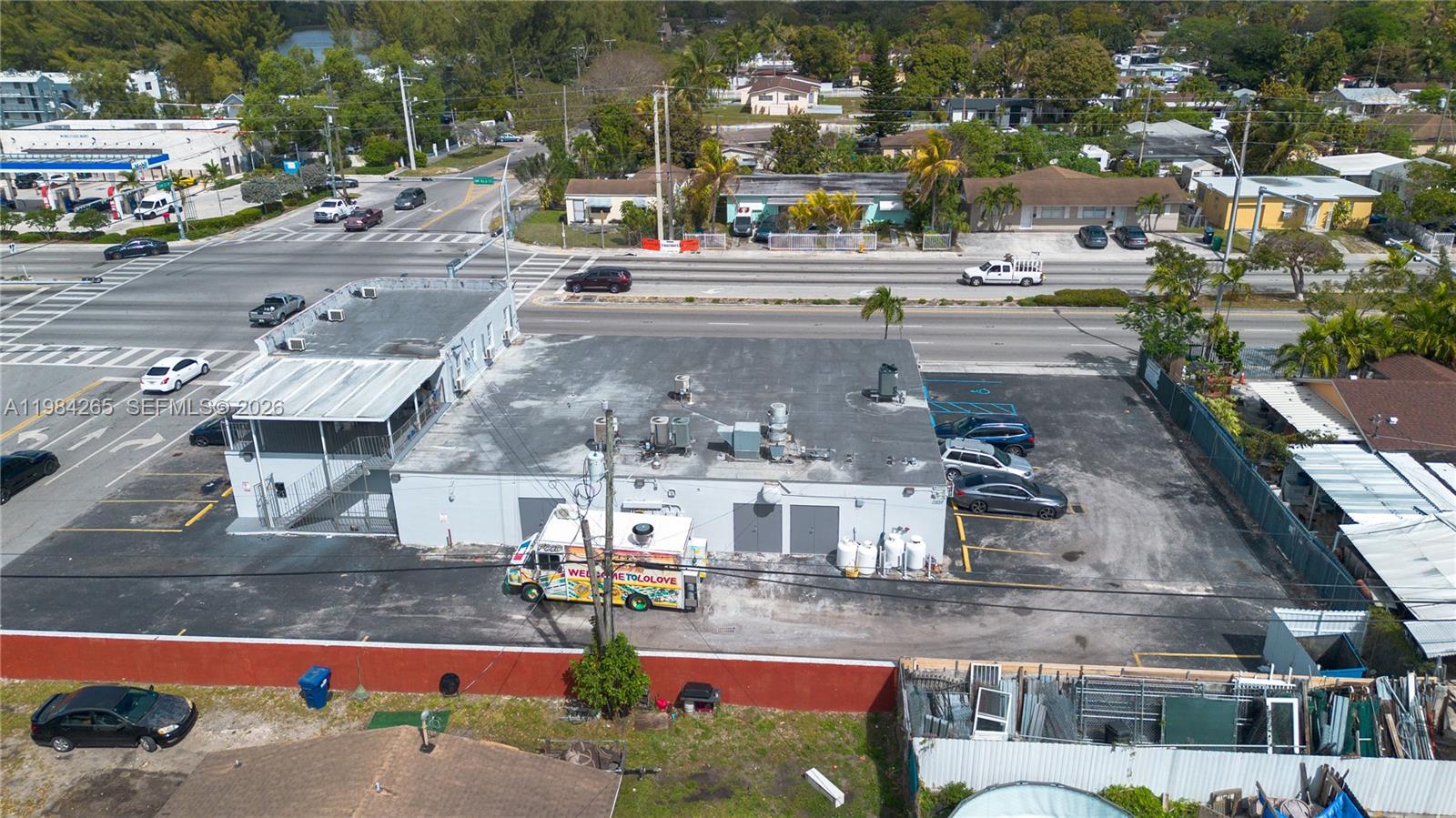 An aerial view shows a commercial building with a parking lot and a food truck — 1186 NW 103rd St, Miami FL 33150, MIAMI, FL
