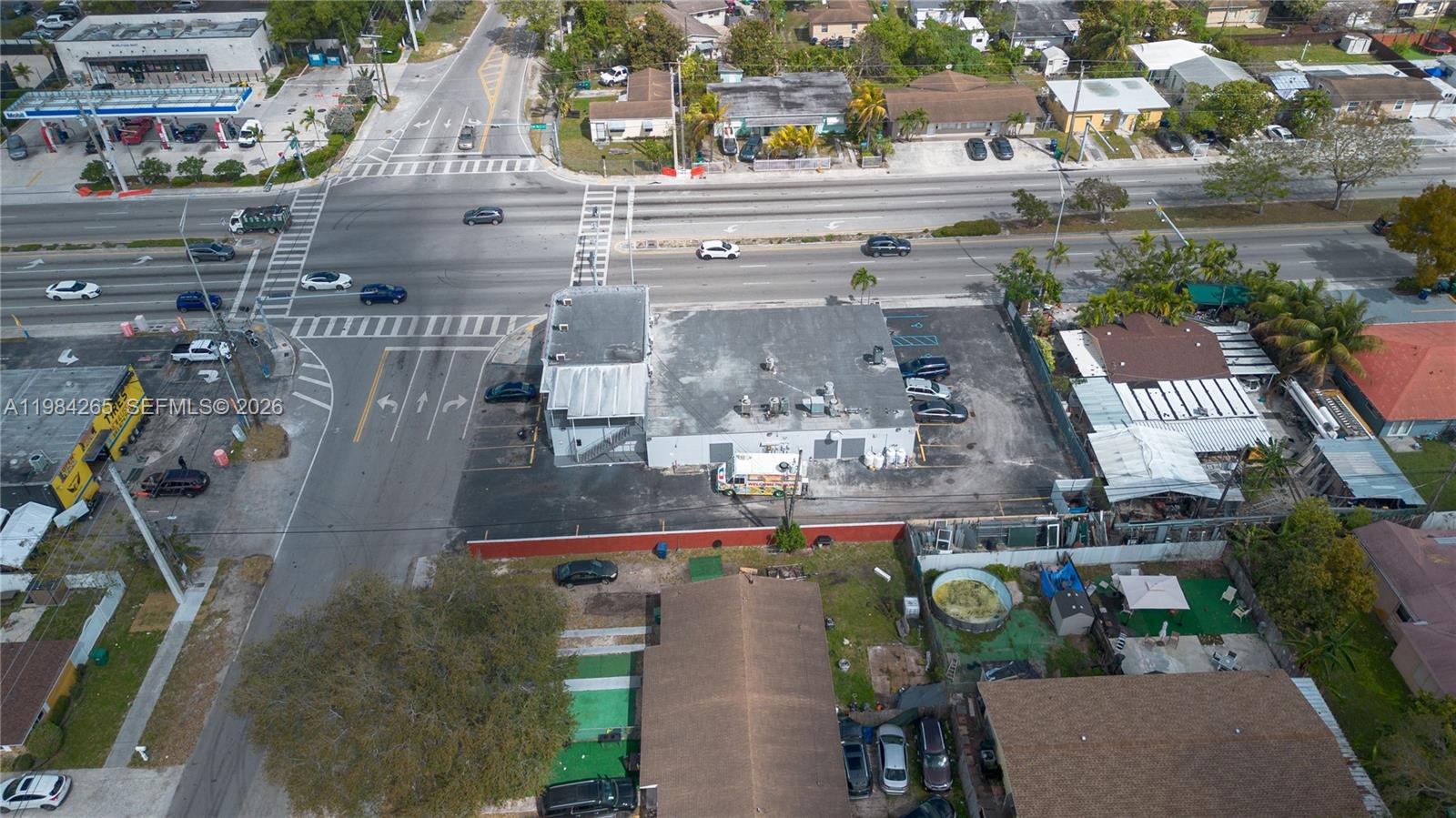 An aerial view shows a commercial building with a parking lot at a street intersection — 1186 NW 103rd St, Miami FL 33150, MIAMI, FL