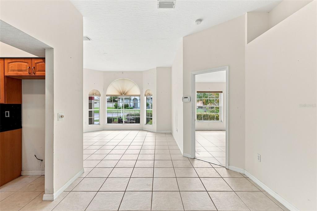 An interior view shows a tiled living area with a bay window and arched doorway — 934 PINE WALK COURT NE, PALM BAY, FL