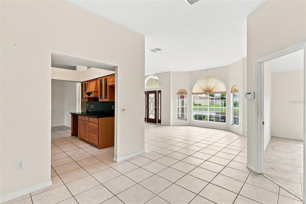 An interior view showing a tiled living area, an open kitchen, and a front entryway — 934 PINE WALK COURT NE, PALM BAY, FL