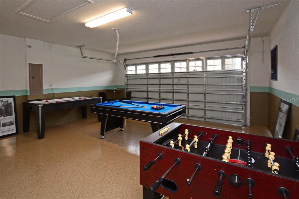 A garage converted into a game room with a foosball table, pool table, and air hockey — 1469 MOON VALLEY DRIVE, DAVENPORT, FL