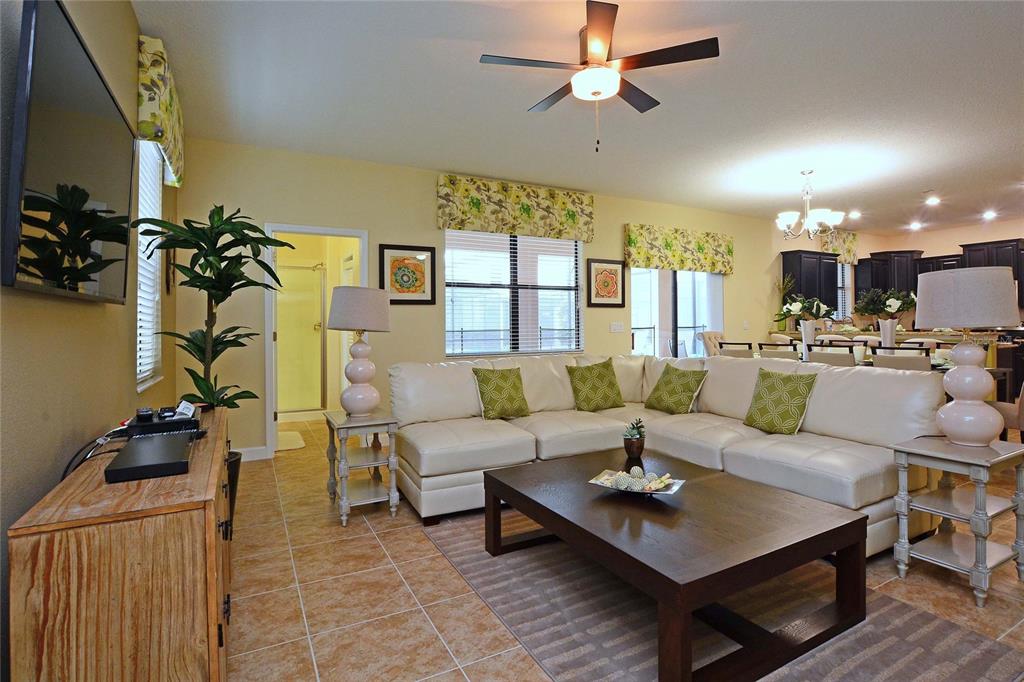 A living room features a white sectional sofa, a dark wood coffee table, and tile flooring — 1469 MOON VALLEY DRIVE, DAVENPORT, FL