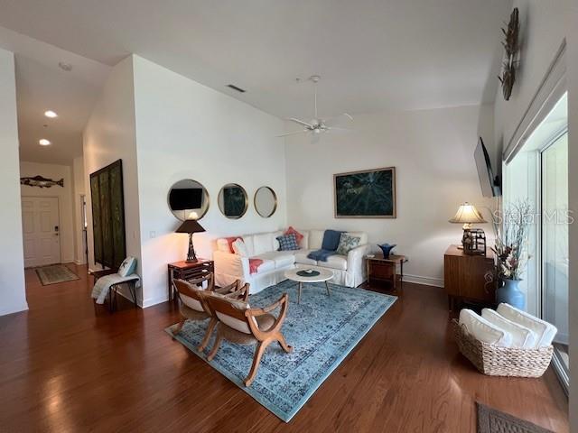 A living room features white walls, hardwood floors, a blue area rug, and white furniture — 5270 HYLAND HILLS AVENUE UNIT 1724, SARASOTA, FL