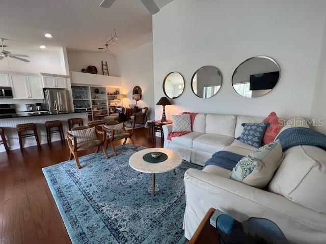 A living room features a white sofa, a blue area rug, and three circular wall mirrors — 5270 HYLAND HILLS AVENUE UNIT 1724, SARASOTA, FL