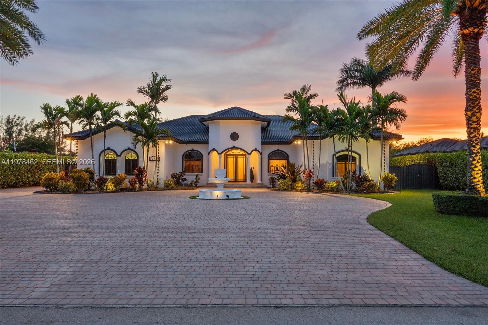 A single-story house with a paved circular driveway, a central fountain, and palm trees — 20120 SW 133rd Ave, Miami FL 33177, MIAMI, FL