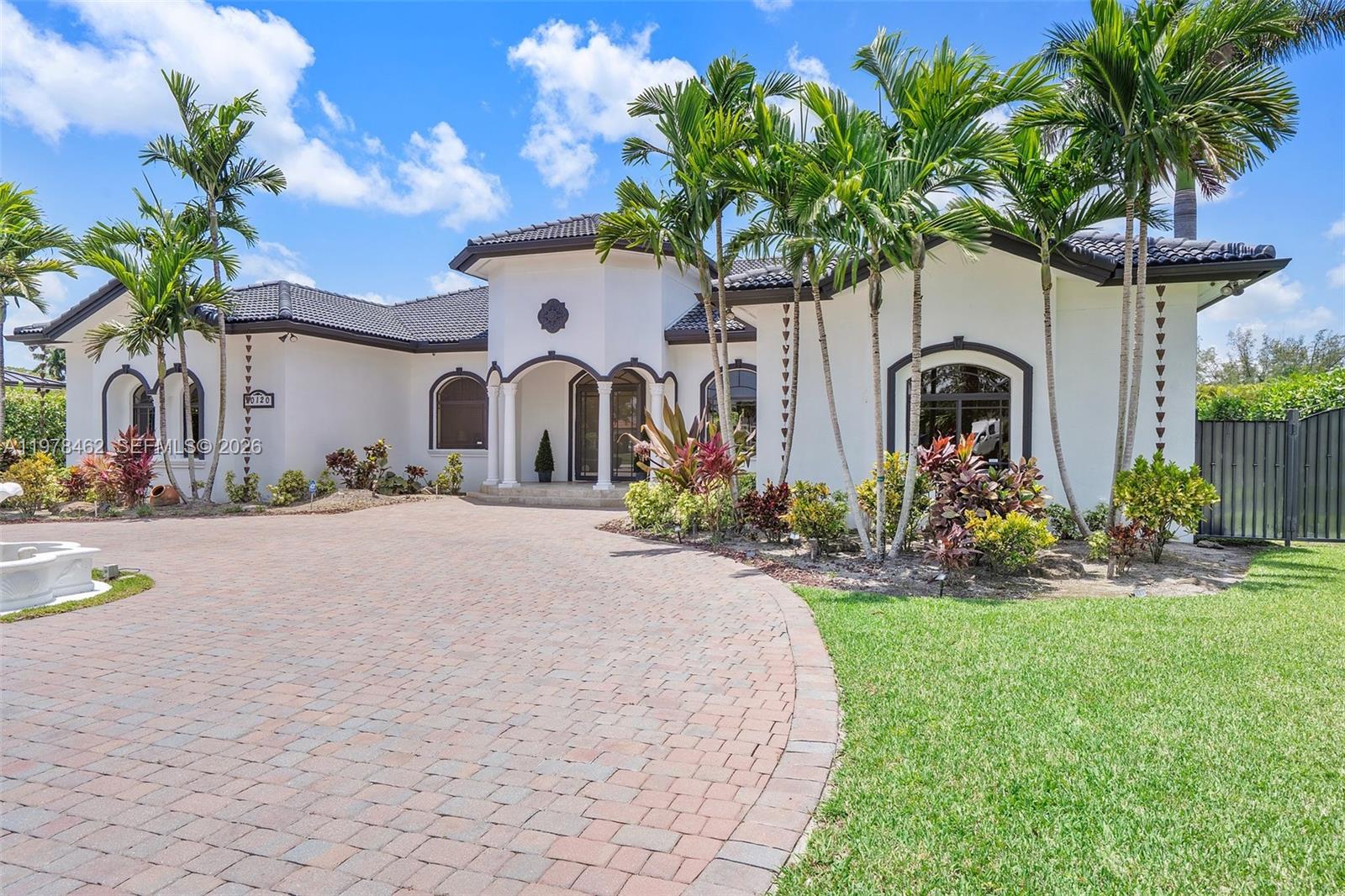 A single-story white house with a dark tile roof and a brick paver driveway — 20120 SW 133rd Ave, Miami FL 33177, MIAMI, FL