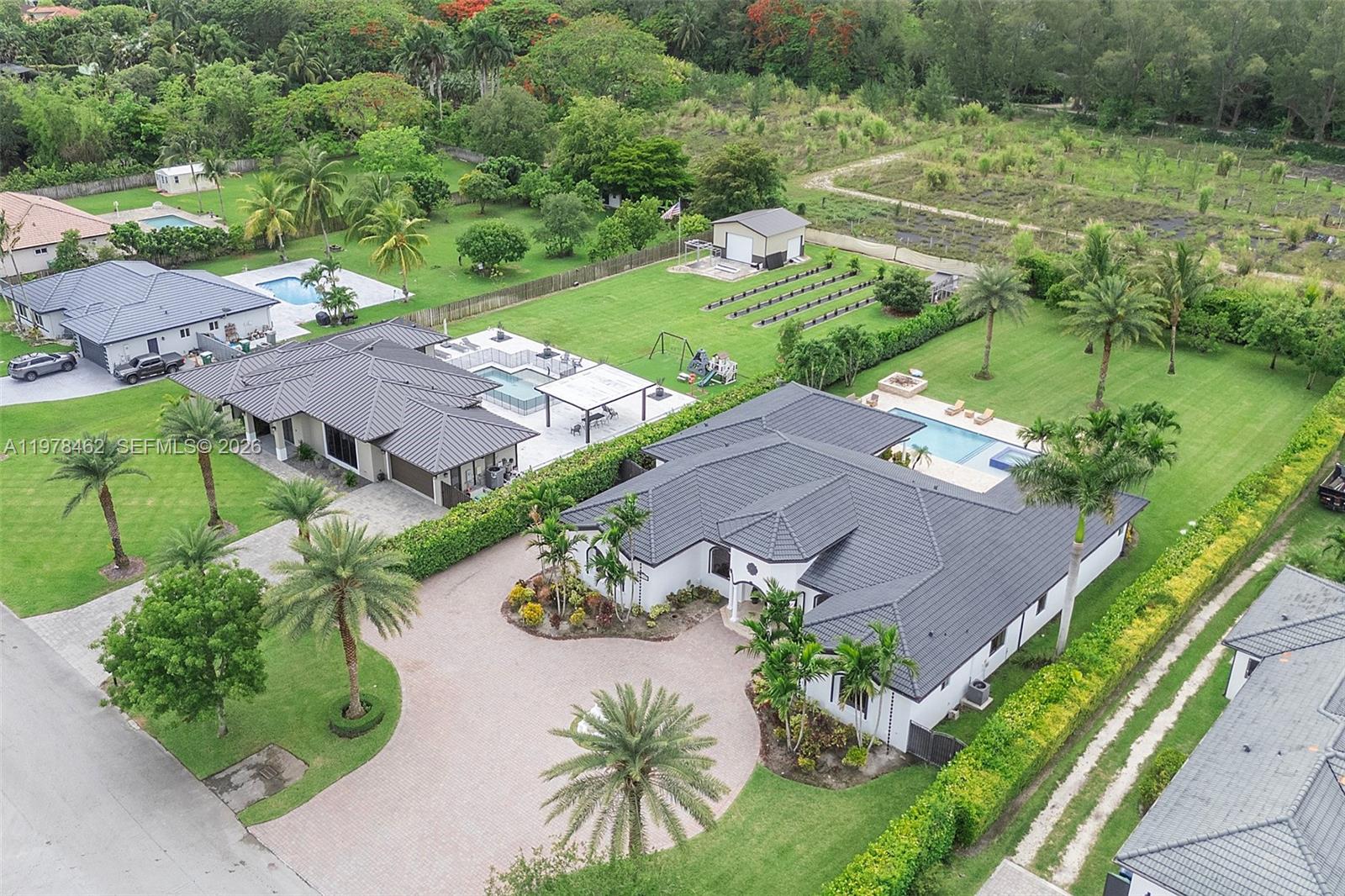 An aerial view shows two large houses with swimming pools and expansive green lawns — 20120 SW 133rd Ave, Miami FL 33177, MIAMI, FL