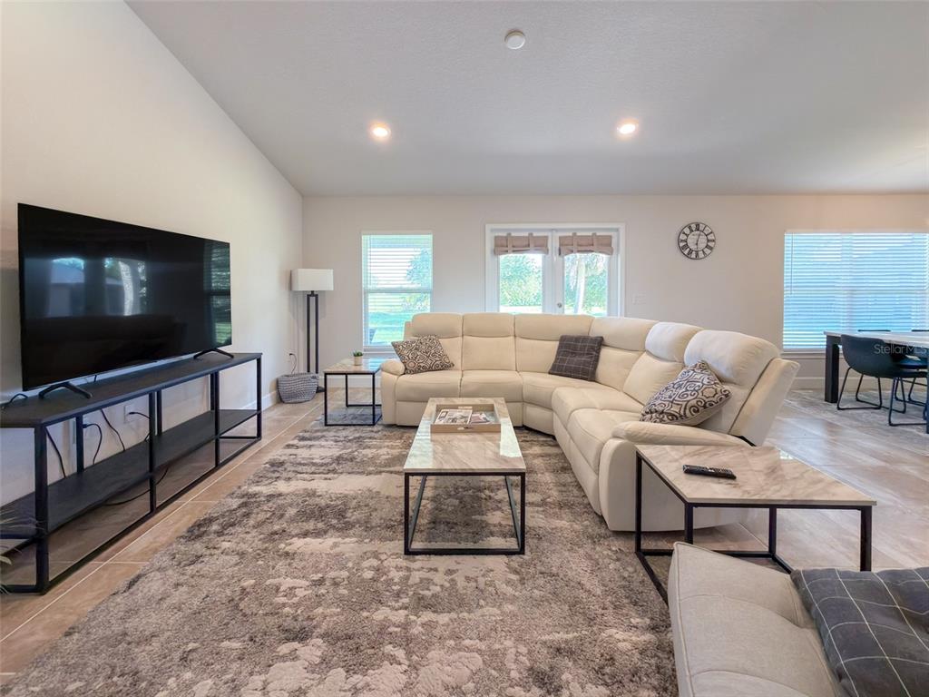 A living room features a white sectional sofa, a marble coffee table, and a television — 249 ROTONDA BOULEVARD W, ROTONDA WEST, FL