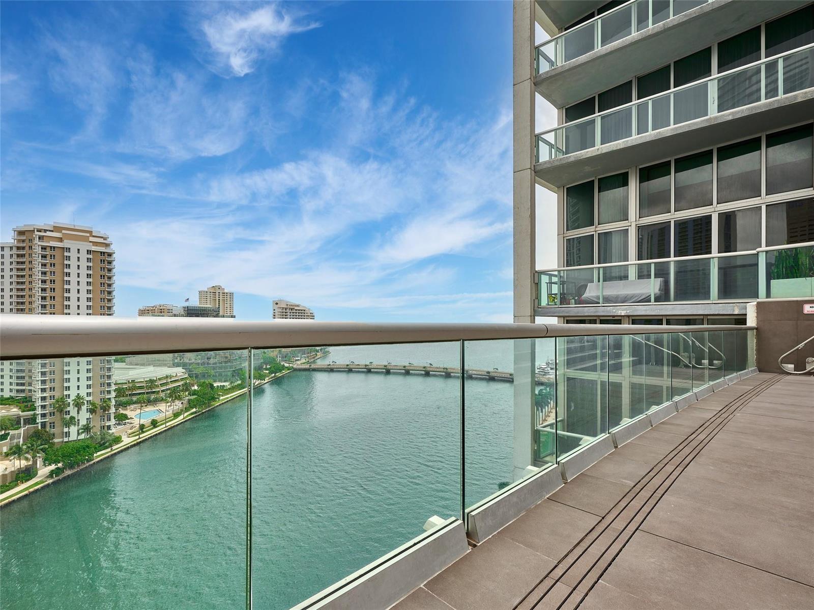 A high-rise balcony with a glass railing overlooks a bay and a bridge — 495 Brickell Avenue # 4506, Miami FL 33131, MIAMI, FL