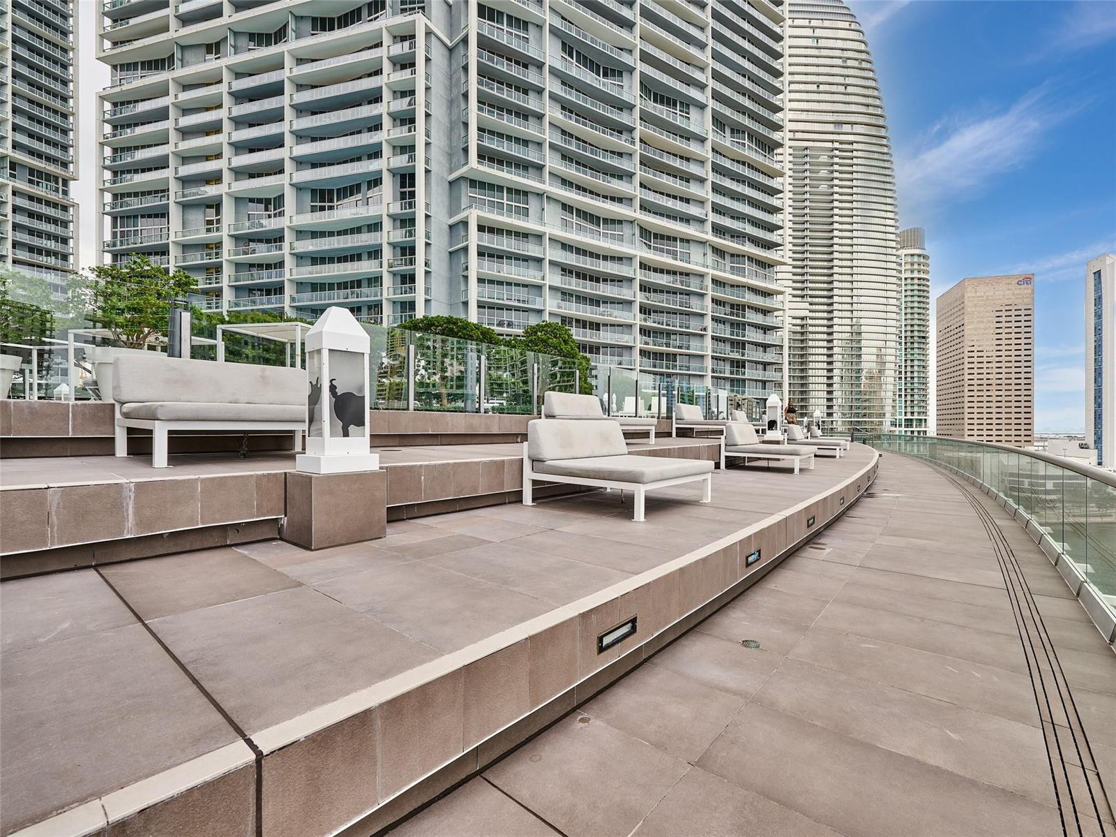 An outdoor terrace features lounge chairs and a glass railing overlooking a city skyline — 495 Brickell Avenue # 4506, Miami FL 33131, MIAMI, FL