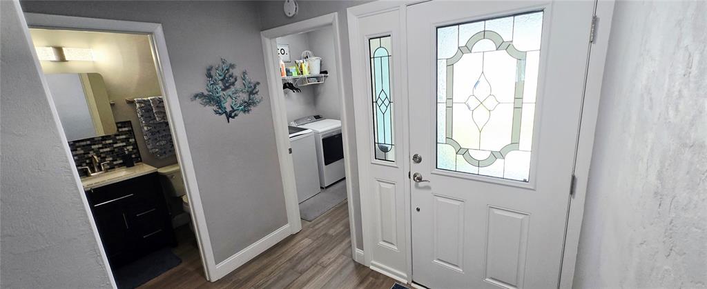 A view of a home entrance showing a bathroom, laundry area, and front door — 68 BRISTOL LANE, PALM COAST, FL