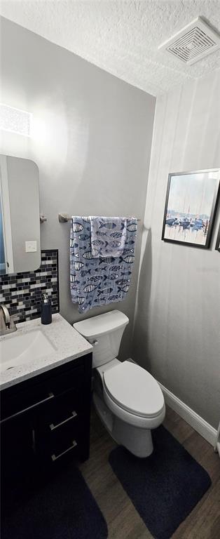 A bathroom features a dark vanity, a white toilet, a fish-patterned towel, and framed wall art — 68 BRISTOL LANE, PALM COAST, FL