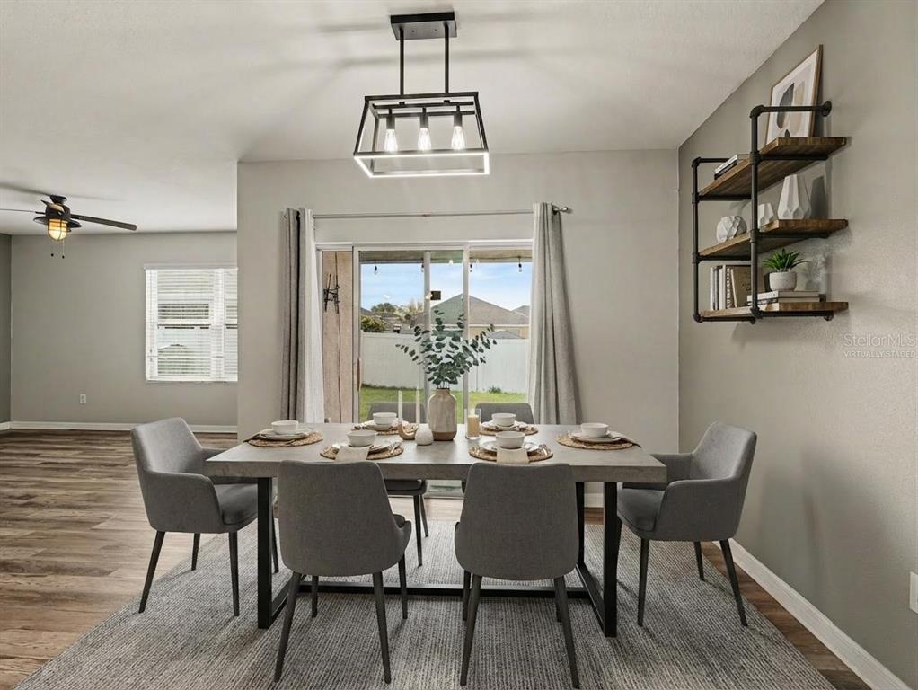 A dining room features a gray table, four chairs, a pendant light, and wall shelving — 10626 PARK MEADOWBROOKE DRIVE, RIVERVIEW, FL