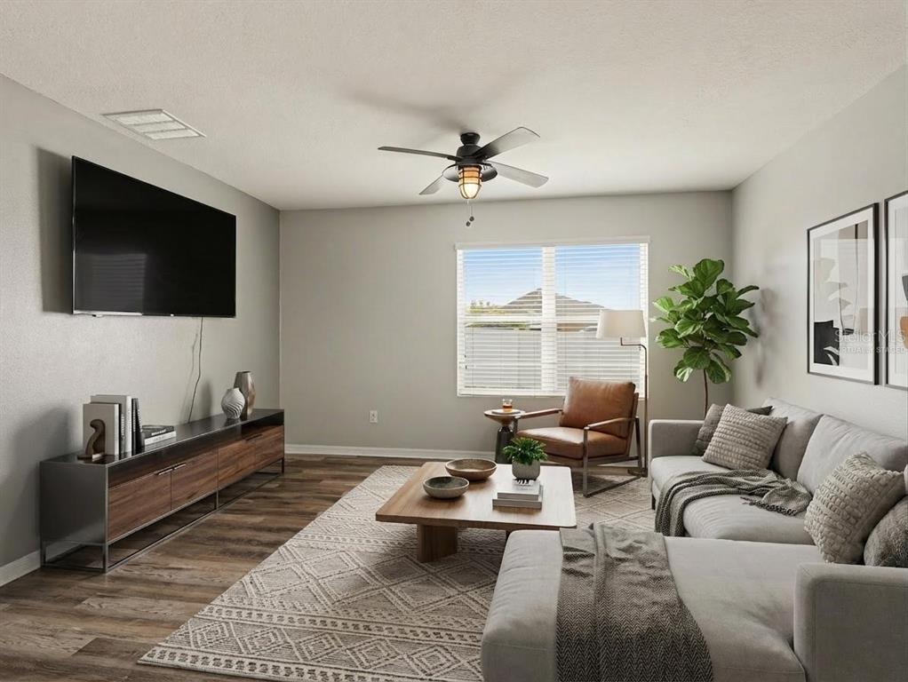 A living room features a sectional sofa, a television, a coffee table, and wood flooring — 10626 PARK MEADOWBROOKE DRIVE, RIVERVIEW, FL