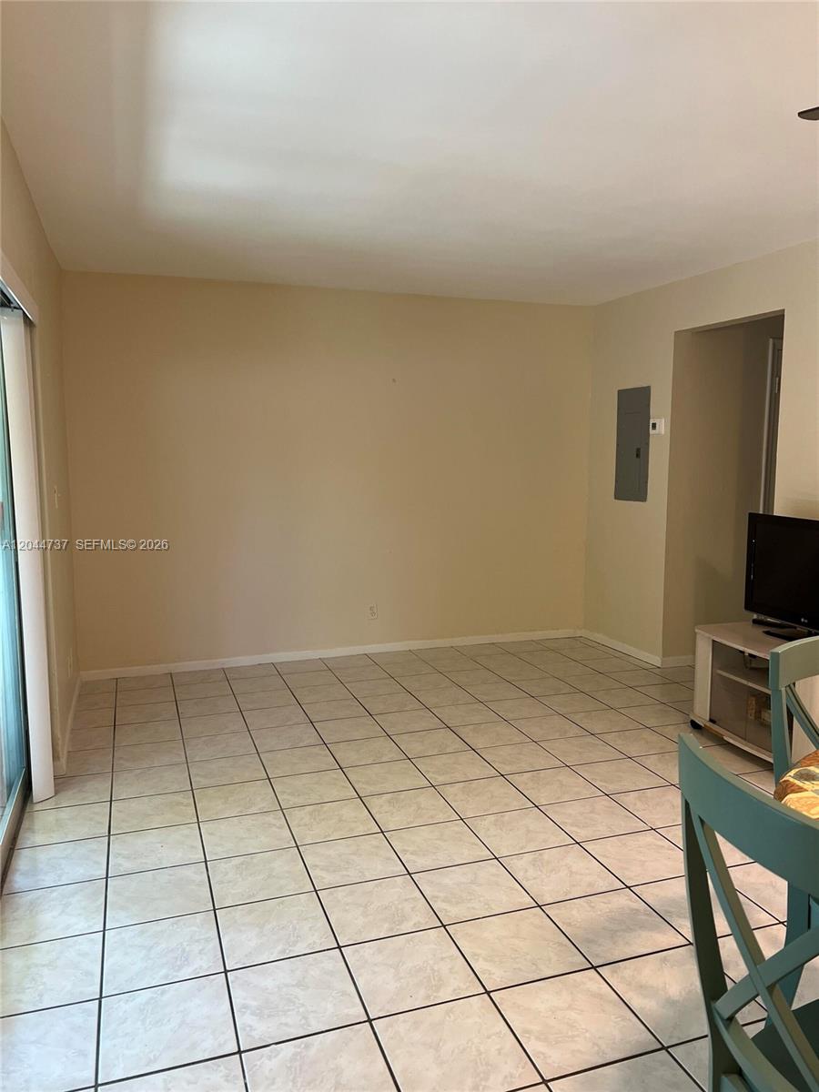 A room with light-colored tile flooring, beige walls, and a sliding glass door — 3745 SW 59th Ave # 124, Davie FL 33314, DAVIE, FL