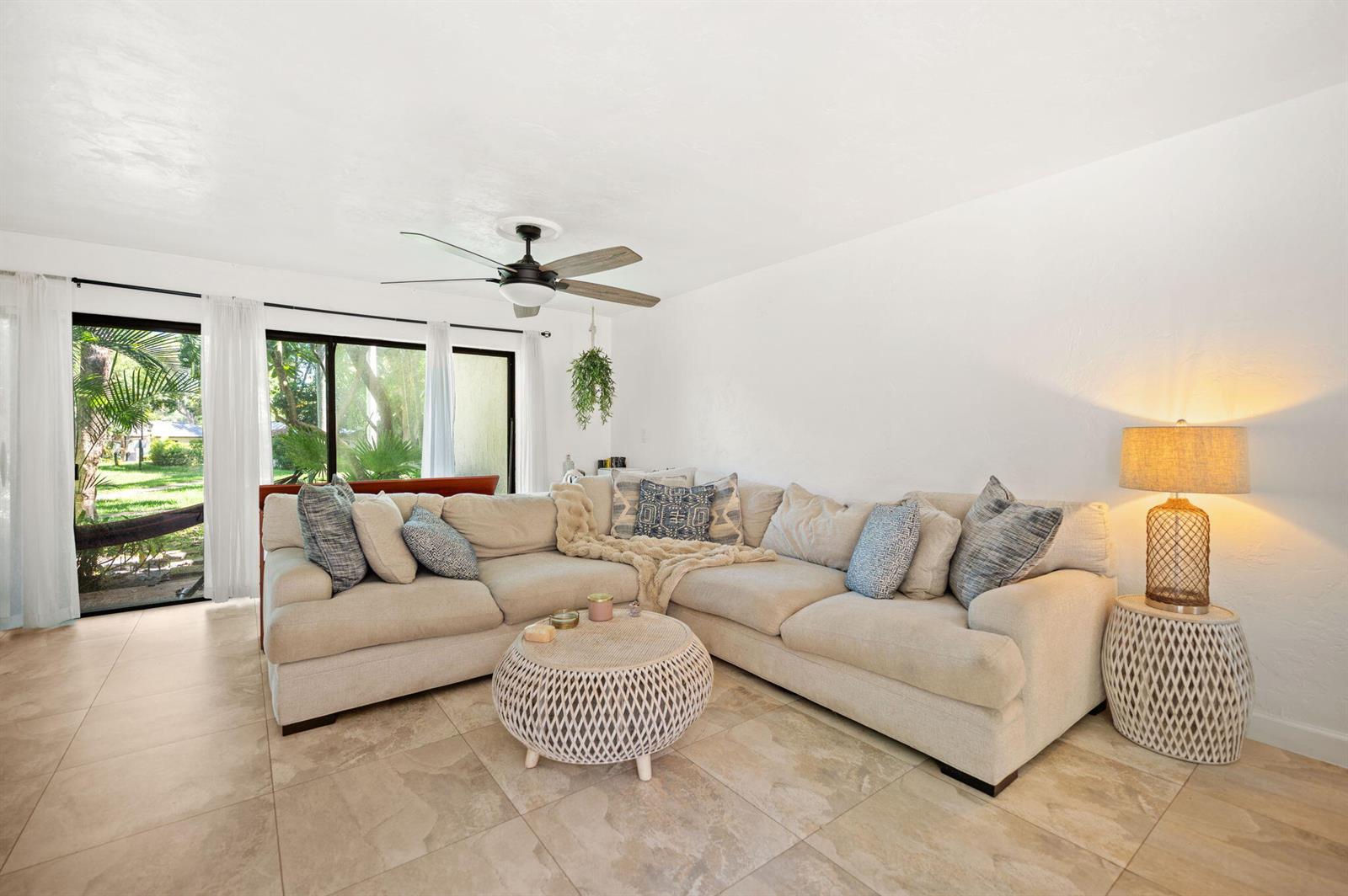 A living room features a beige sectional sofa, a round coffee table, and sliding glass doors — 3407 Cherry Garden Circle # 151, Lauderhill FL 33319, LAUDERHILL, FL