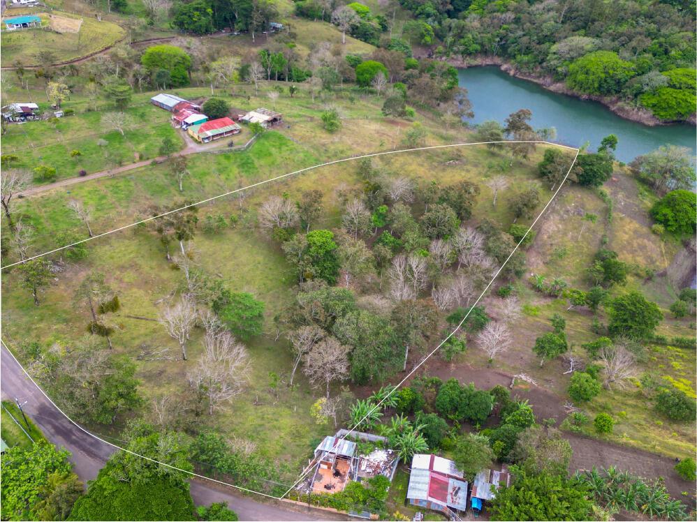 An aerial view shows a grassy plot of land outlined in white near a lake — Lot 7 Guanacaste Province, Tronadora, FL