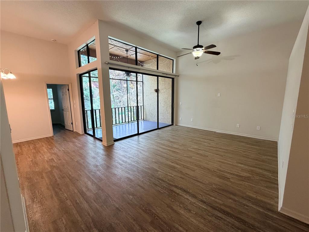 A living room with wood-look flooring, a ceiling fan, and a screened-in balcony — 2867 MARSALA COURT UNIT 2867, ORLANDO, FL