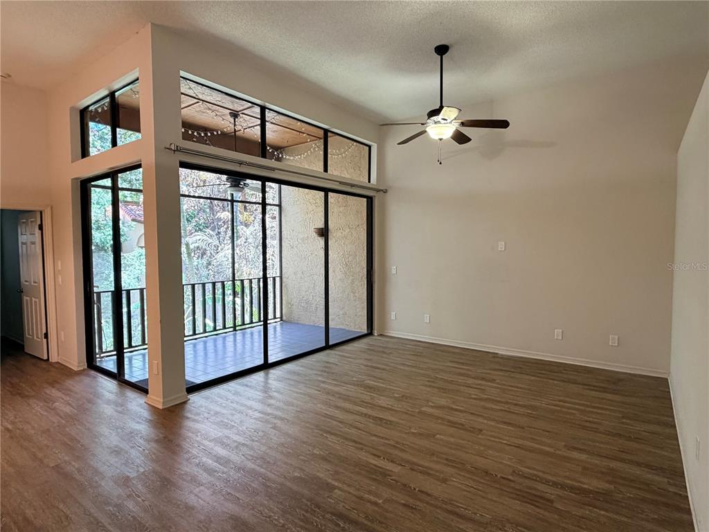 A living room with wood-look flooring, a ceiling fan, and sliding glass doors to a patio — 2867 MARSALA COURT UNIT 2867, ORLANDO, FL