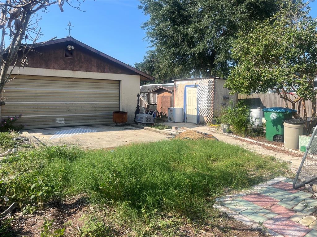 A detached garage with a concrete driveway sits next to a small shed and yard — 214 INDIAN CREEK ROAD, OAK HILL, FL