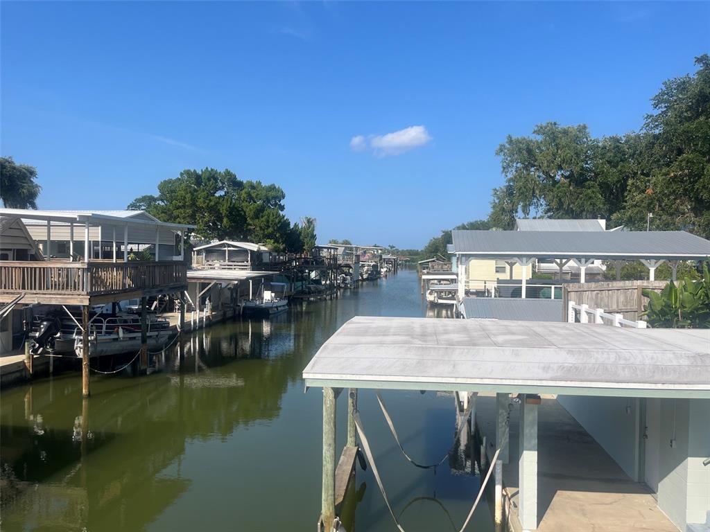 A canal view showing several stilt houses with boat docks and covered boat slips — 214 INDIAN CREEK ROAD, OAK HILL, FL