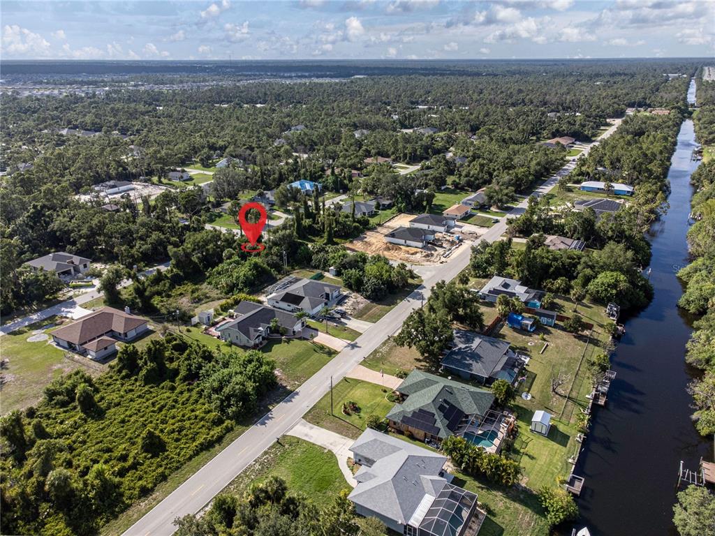 An aerial view shows a residential neighborhood with a red location pin over a lot — 17221 NIXON AVENUE, PORT CHARLOTTE, FL