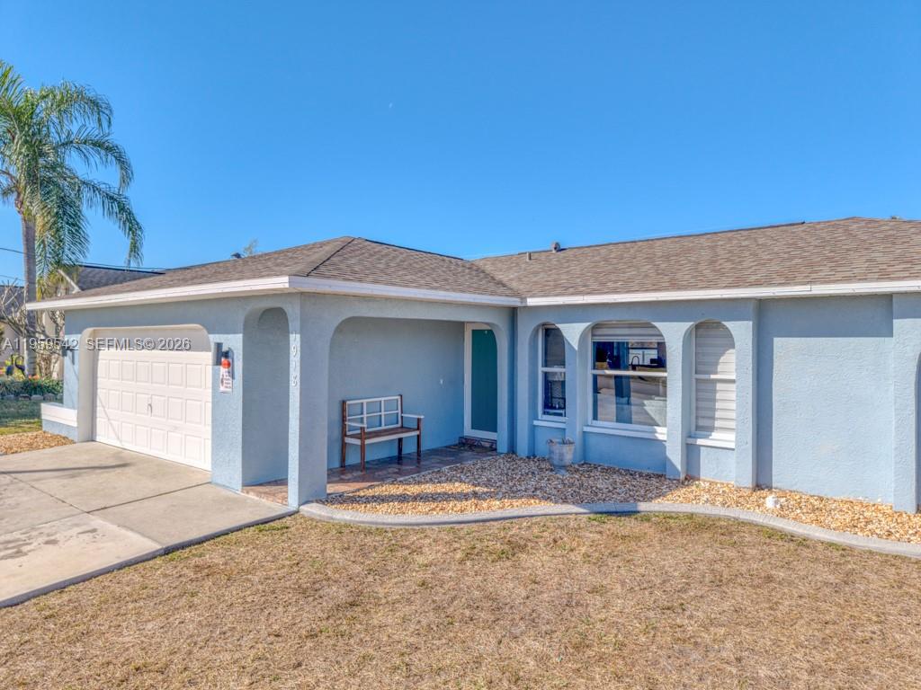A single-story house with a light blue stucco exterior, a garage, and a covered porch — 1918 SE 5th ct, Cape Coral FL 33990, CAPE CORAL, FL