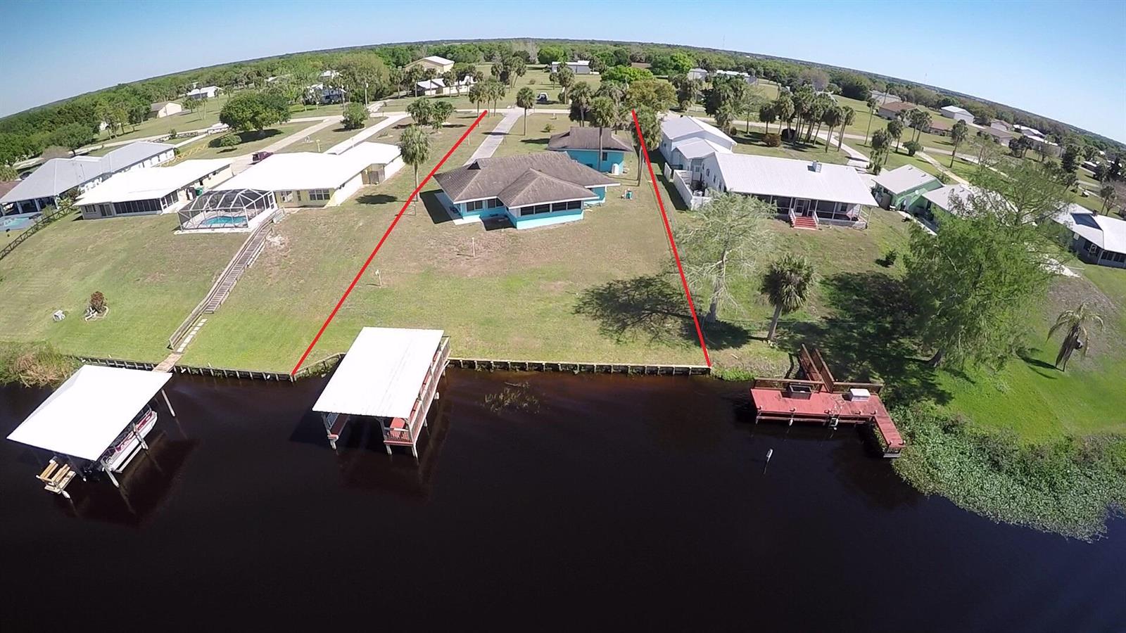 An aerial view shows a waterfront house with a boat dock and a large yard — 13578 SW 144th Parkway, Okeechobee FL 34974, OKEECHOBEE, FL