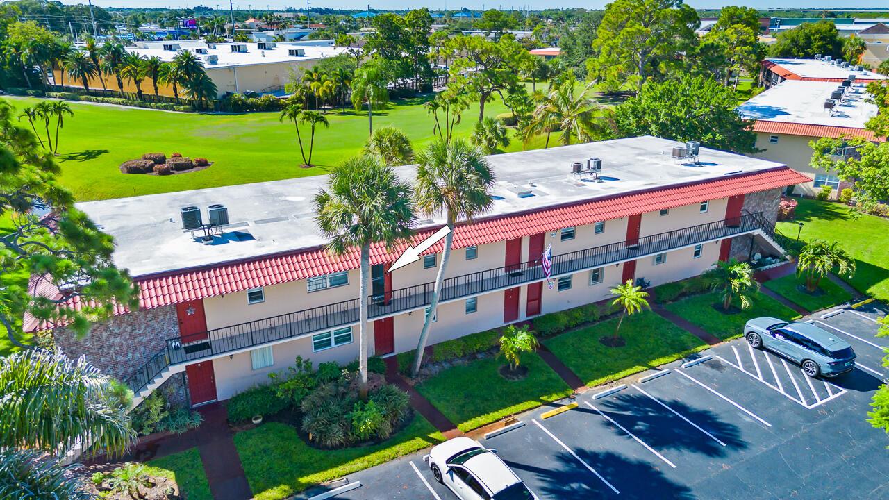 An aerial view of a two-story apartment building with a red tile roof and balconies — 1975 SW Palm City Road # G, Stuart FL 34994, STUART, FL