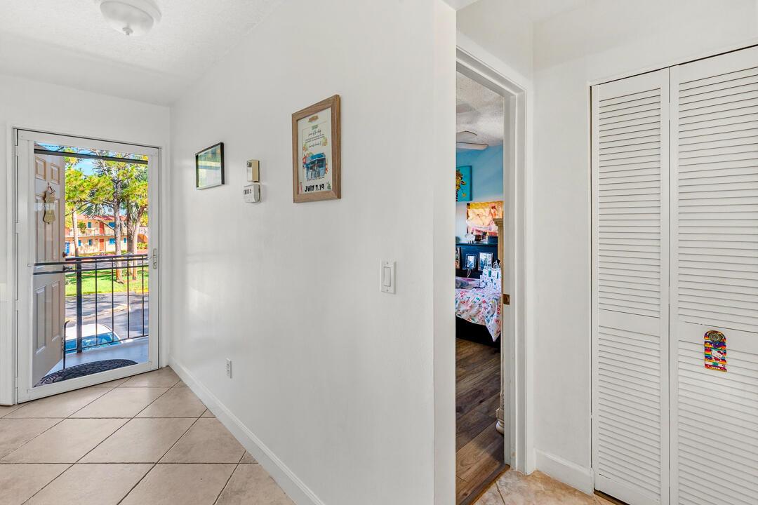 A tiled entryway leads to a bedroom doorway and a white louvered closet door — 1975 SW Palm City Road # G, Stuart FL 34994, STUART, FL