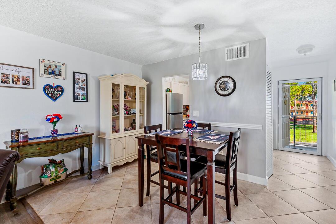 A dining area with a wooden table, hutch, console table, and tile flooring — 1975 SW Palm City Road # G, Stuart FL 34994, STUART, FL