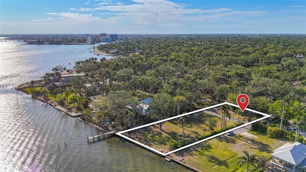 An aerial view shows a rectangular waterfront lot outlined in white with a private dock — 408 31ST STREET NW, BRADENTON, FL